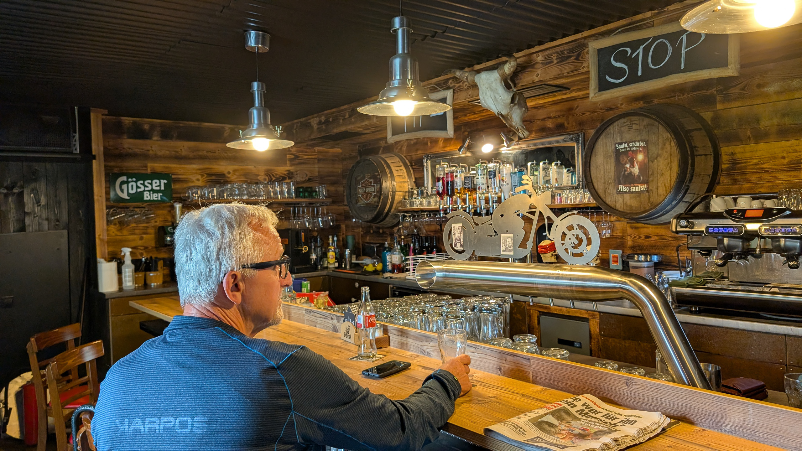 Rast in einem Lokal unterwegs – Holzbar mit Gösser-Schild und Motorrad-Deko